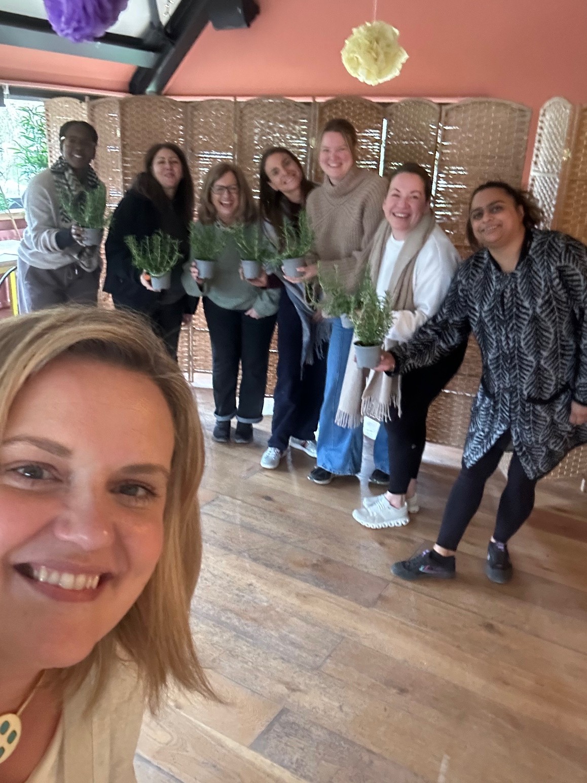 Group selfie with retreat participants holding plants